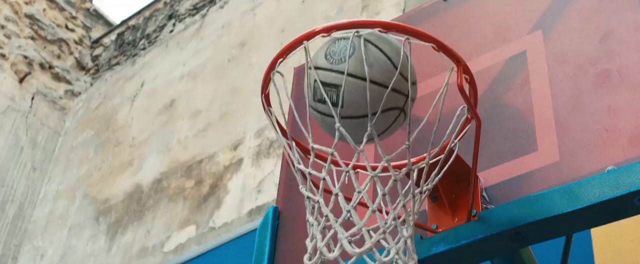 a basketball going through the net of a basketball hoop