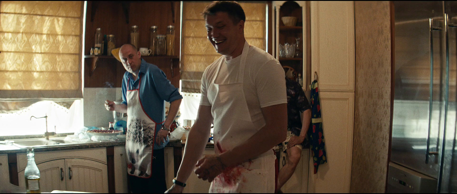 a couple of men standing in a kitchen