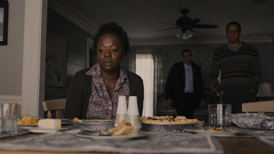 a woman sitting at a table in front of a plate of food