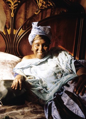 a woman laying on a bed with a blue blanket