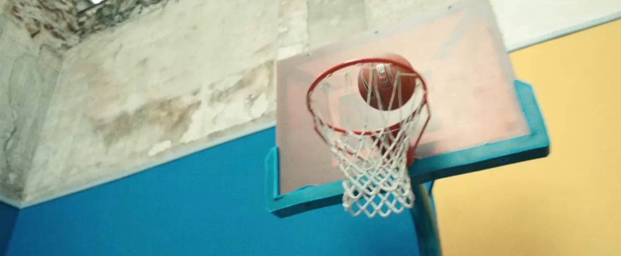 a basketball going through the net of a basketball hoop