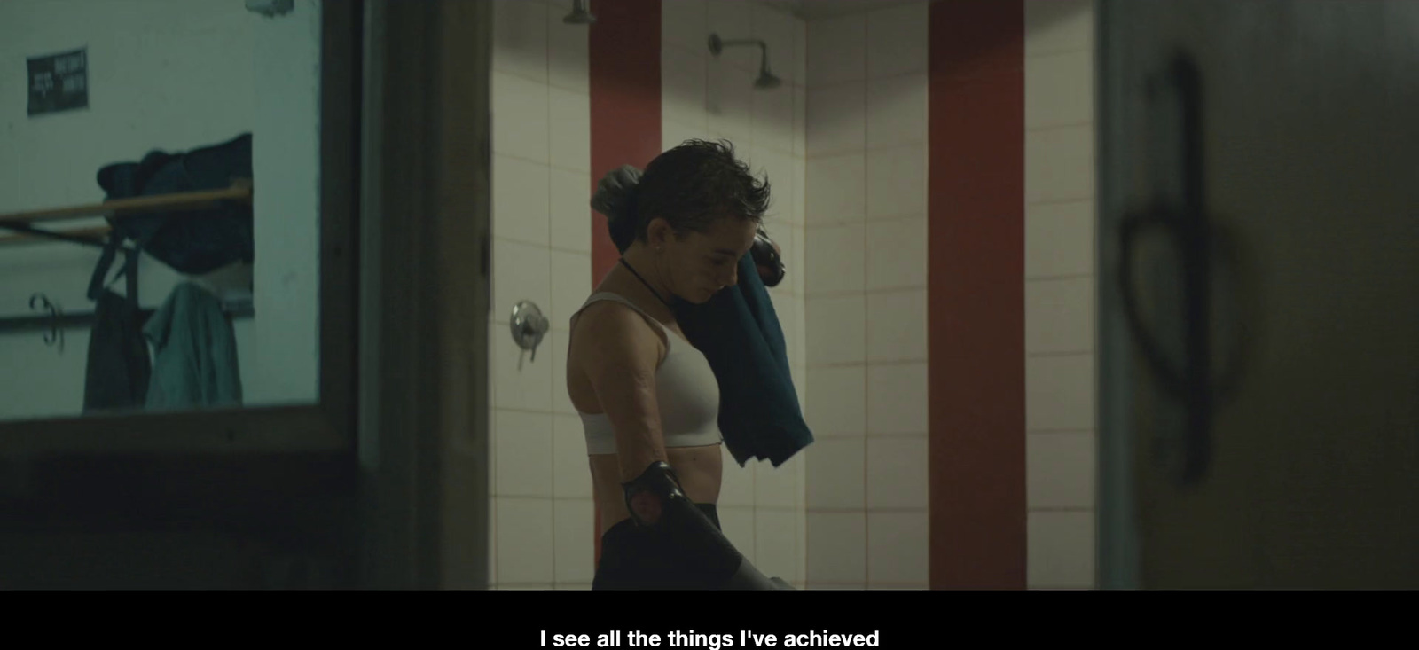 a woman standing in a bathroom holding a towel