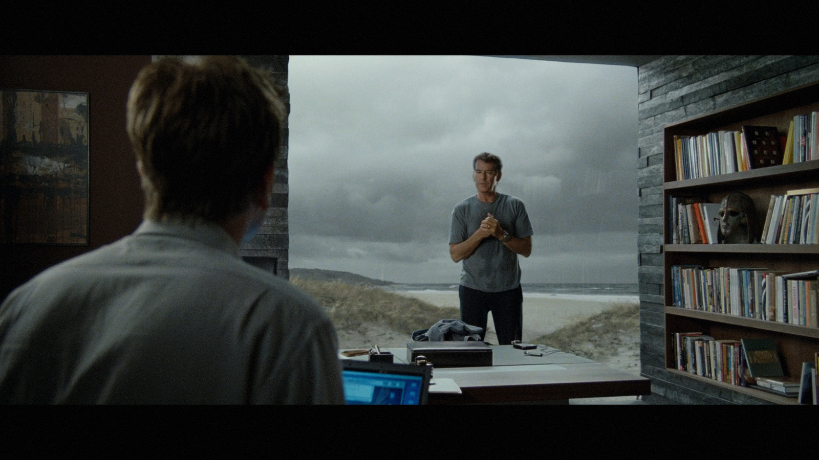 a man standing in front of a book shelf