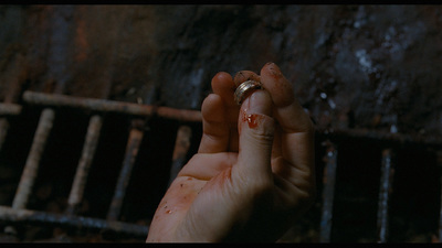 a hand holding a ring with blood on it