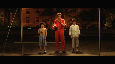 three young boys standing in front of a pole