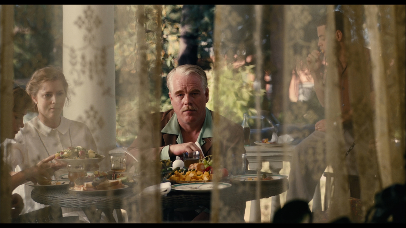 a man sitting at a table with a plate of food