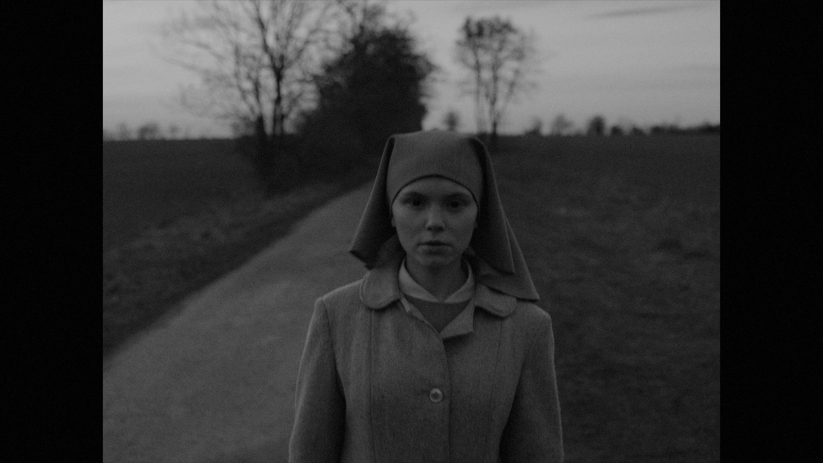 a woman in a nun outfit standing on a road