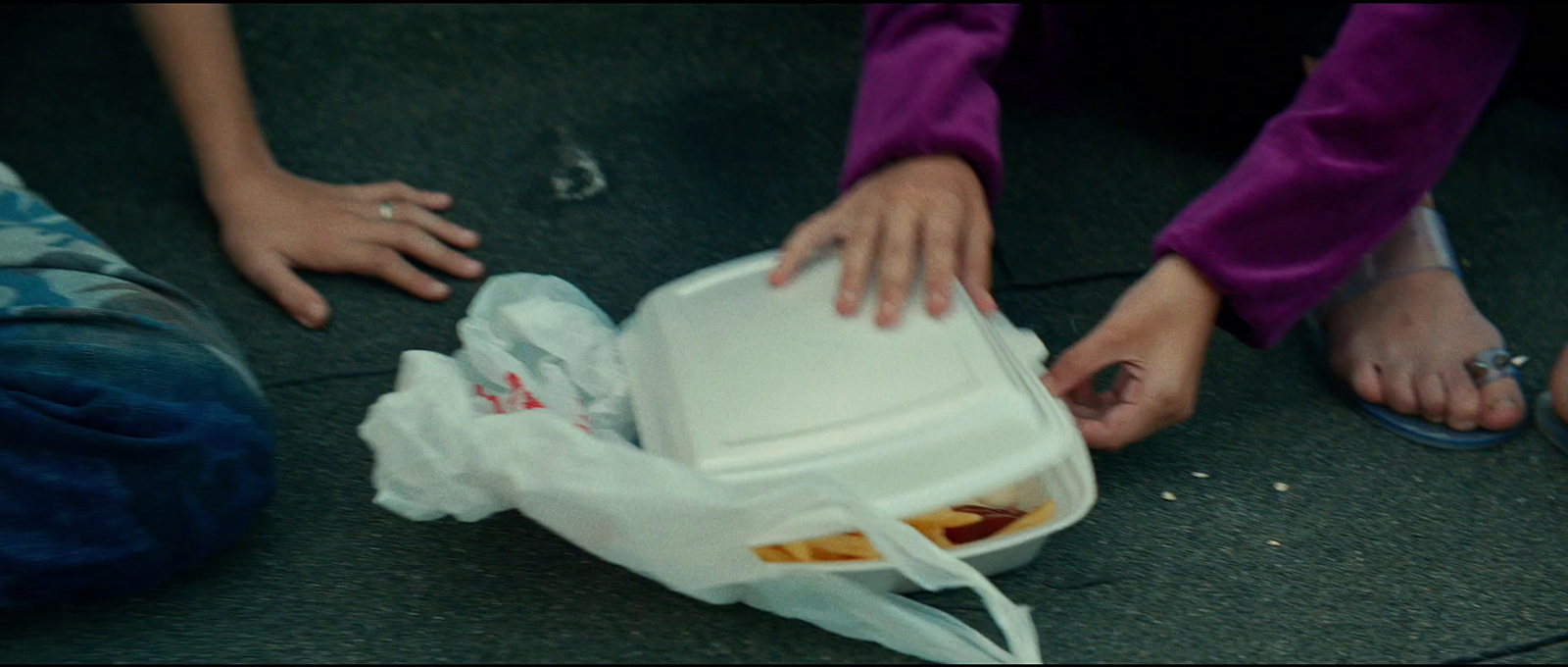 a group of people standing around a container of food