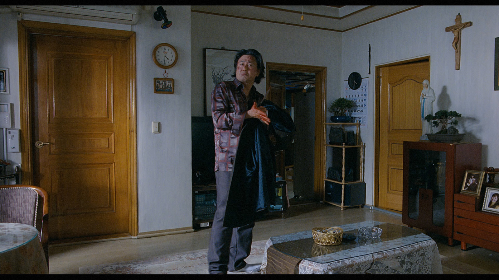 a man standing in a living room next to a table