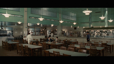 a group of people standing in a kitchen next to tables