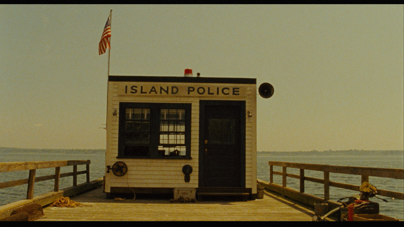 a small boathouse sitting on a pier next to the ocean