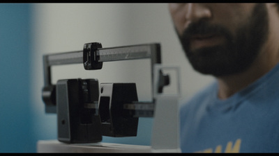 a man standing next to a scale with a weight on it