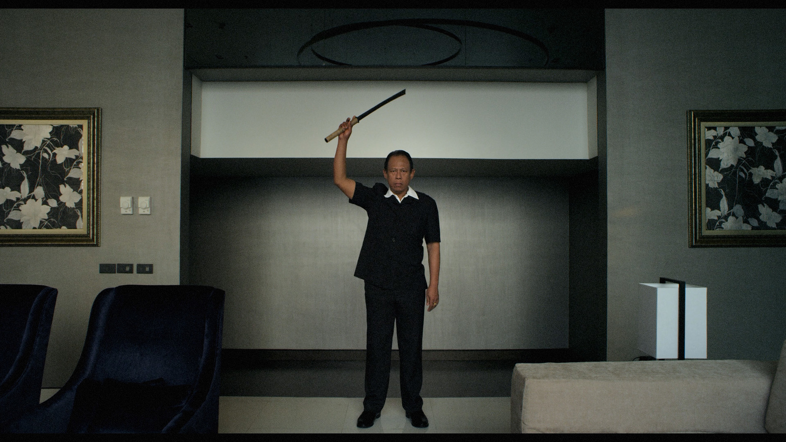 a man holding a baseball bat in a room