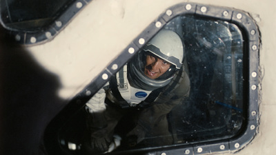 a man in a space suit is reflected in a mirror