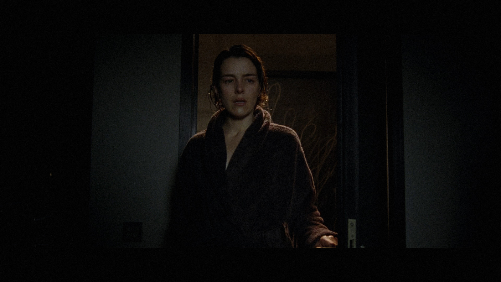 a woman in a robe standing in a dark room