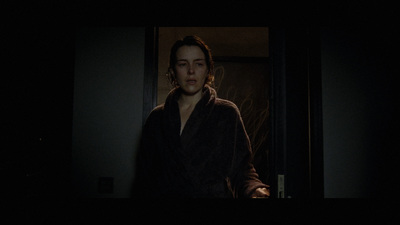 a woman in a robe standing in a dark room