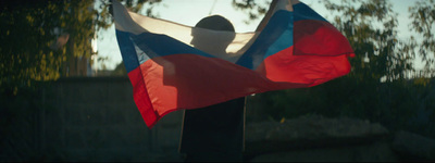 a person holding a flag in front of a tree