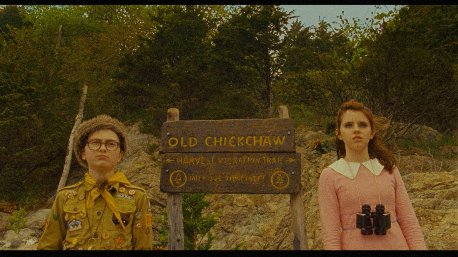 a man and a woman standing next to a sign