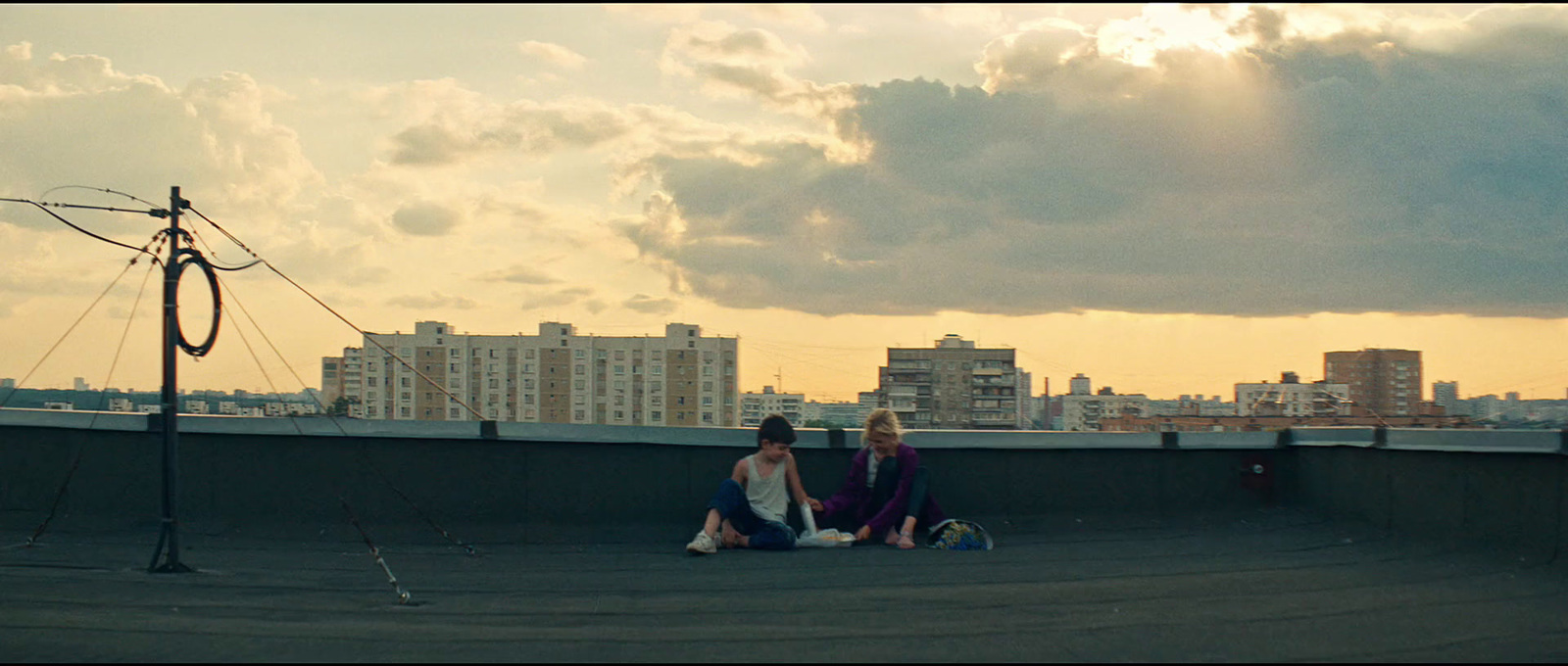 a couple of women sitting on top of a roof