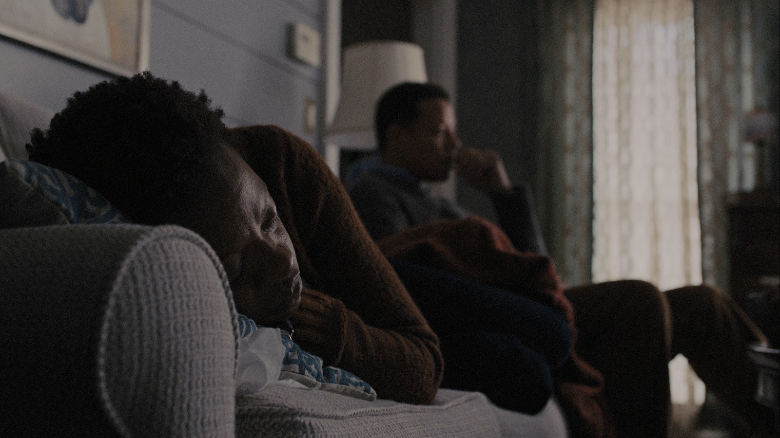 two people sitting on a couch in a living room