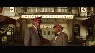 a couple of men standing next to each other in front of a building