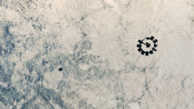 a group of people standing in the middle of a snow covered field