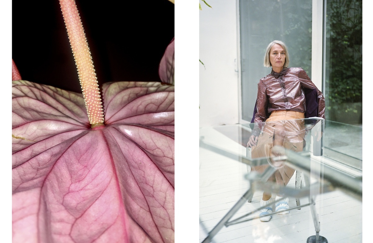 a woman sitting in a chair next to a large flower