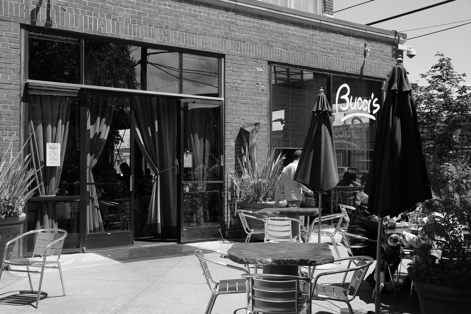 a black and white photo of a patio with tables and chairs