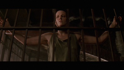 a man standing behind bars in a jail cell