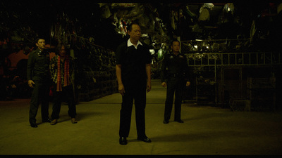 a man in a suit standing in a dark room