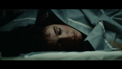 a woman laying in bed with her eyes closed