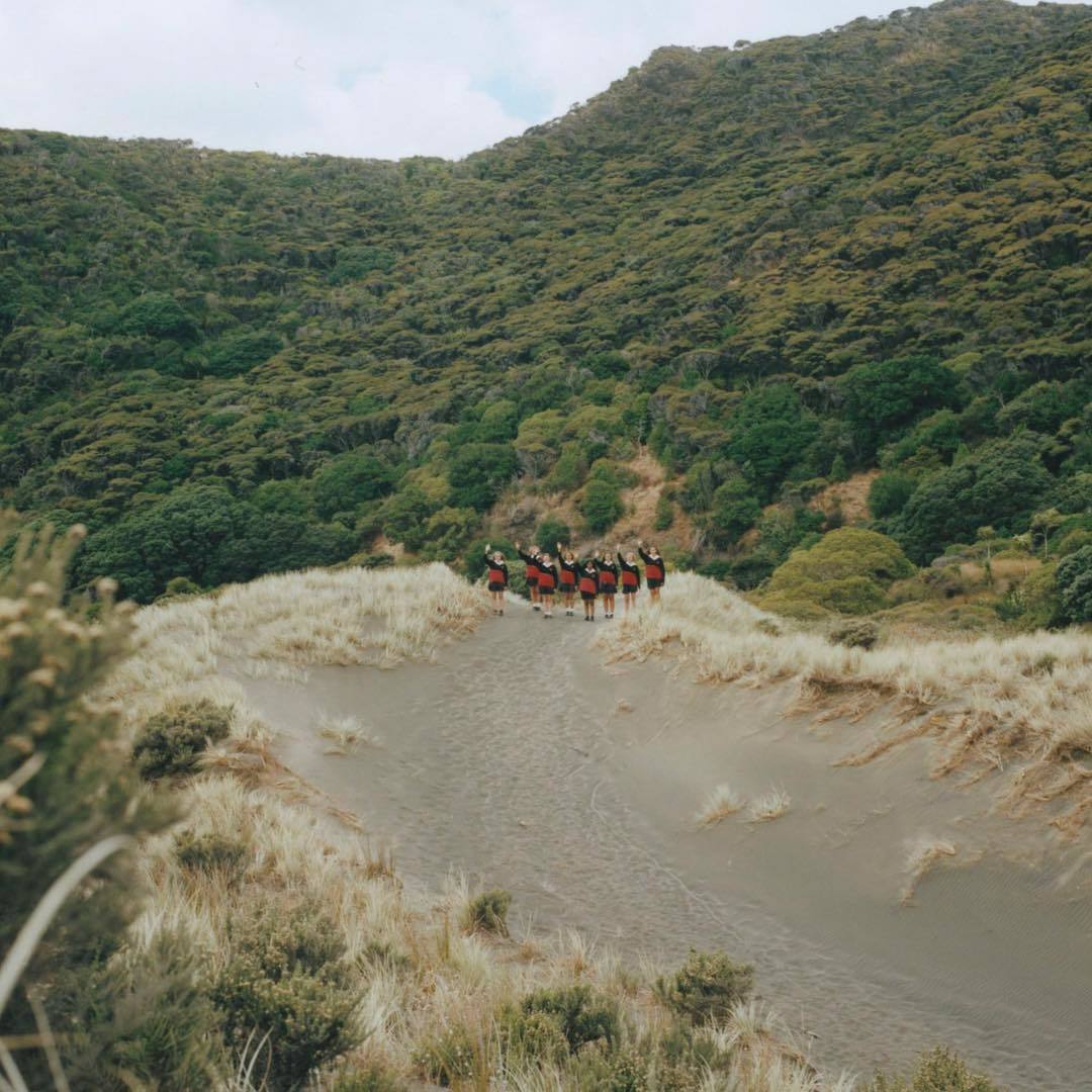 a group of people riding horses down a dirt road