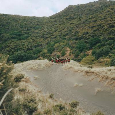 a group of people riding horses down a dirt road