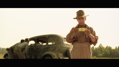 a man standing next to a green car in a field