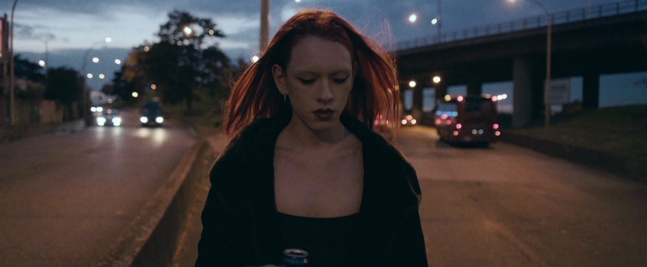 a woman with red hair walking down a street