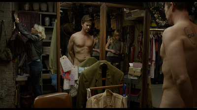 a shirtless man standing in front of a mirror