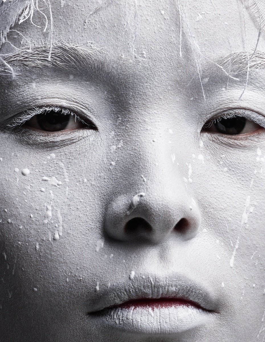 a woman with white paint on her face