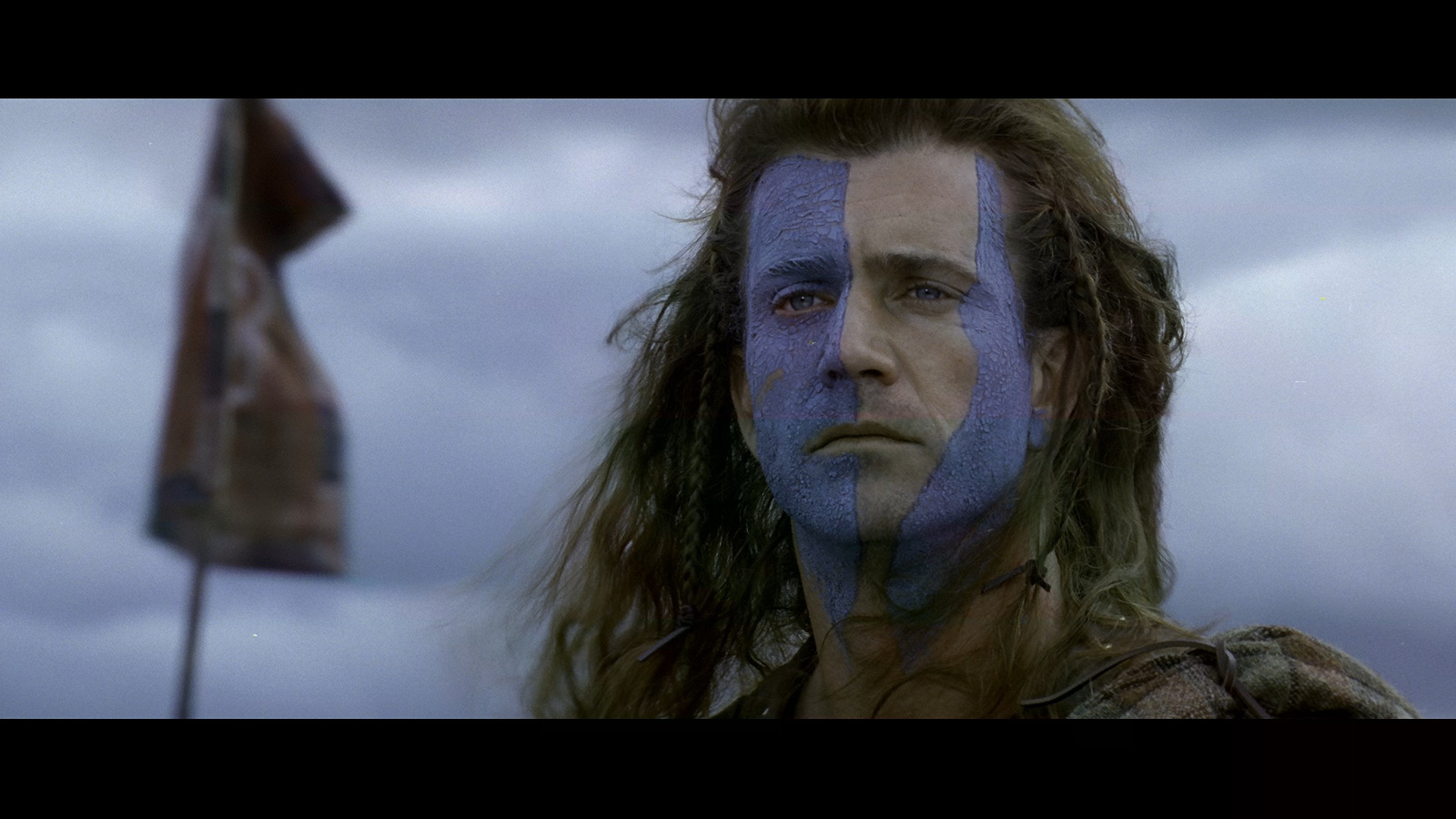 a man with long hair and blue face paint