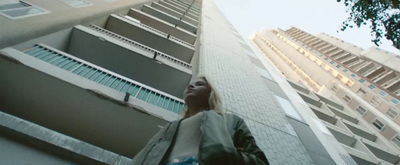 a woman standing in front of a tall building