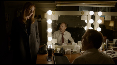 a man and a woman standing in front of a mirror