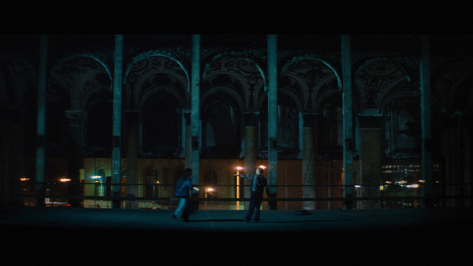 two people standing in front of a building at night