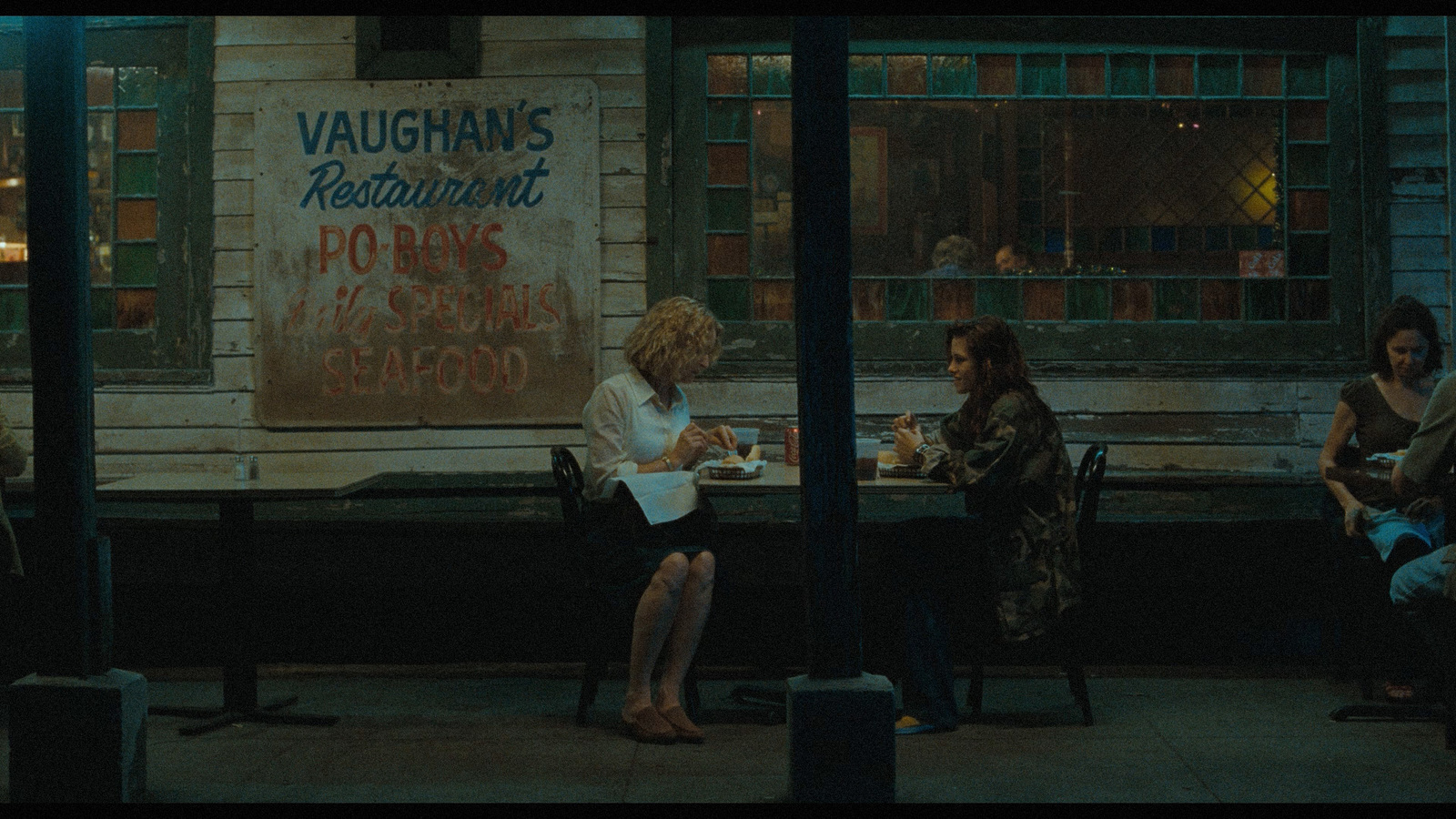 a group of people sitting at a table outside of a restaurant