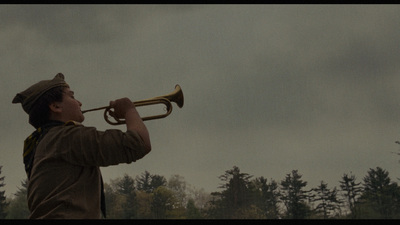 a man playing a trumpet on a cloudy day