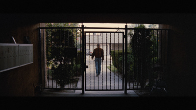 a man walking out of a gate into a yard