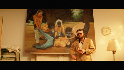 a man standing in front of a painting holding a drink