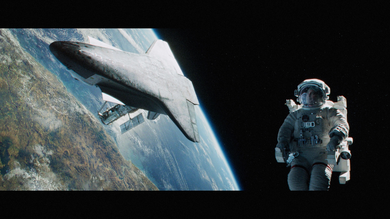 a man in a space suit standing next to a space shuttle