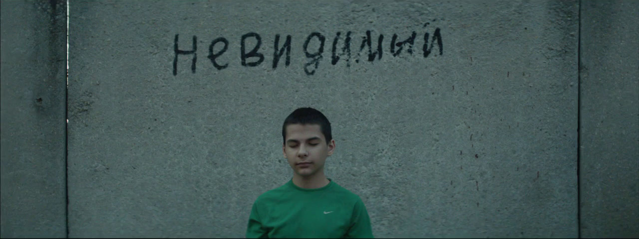 a man standing in front of a wall with graffiti on it