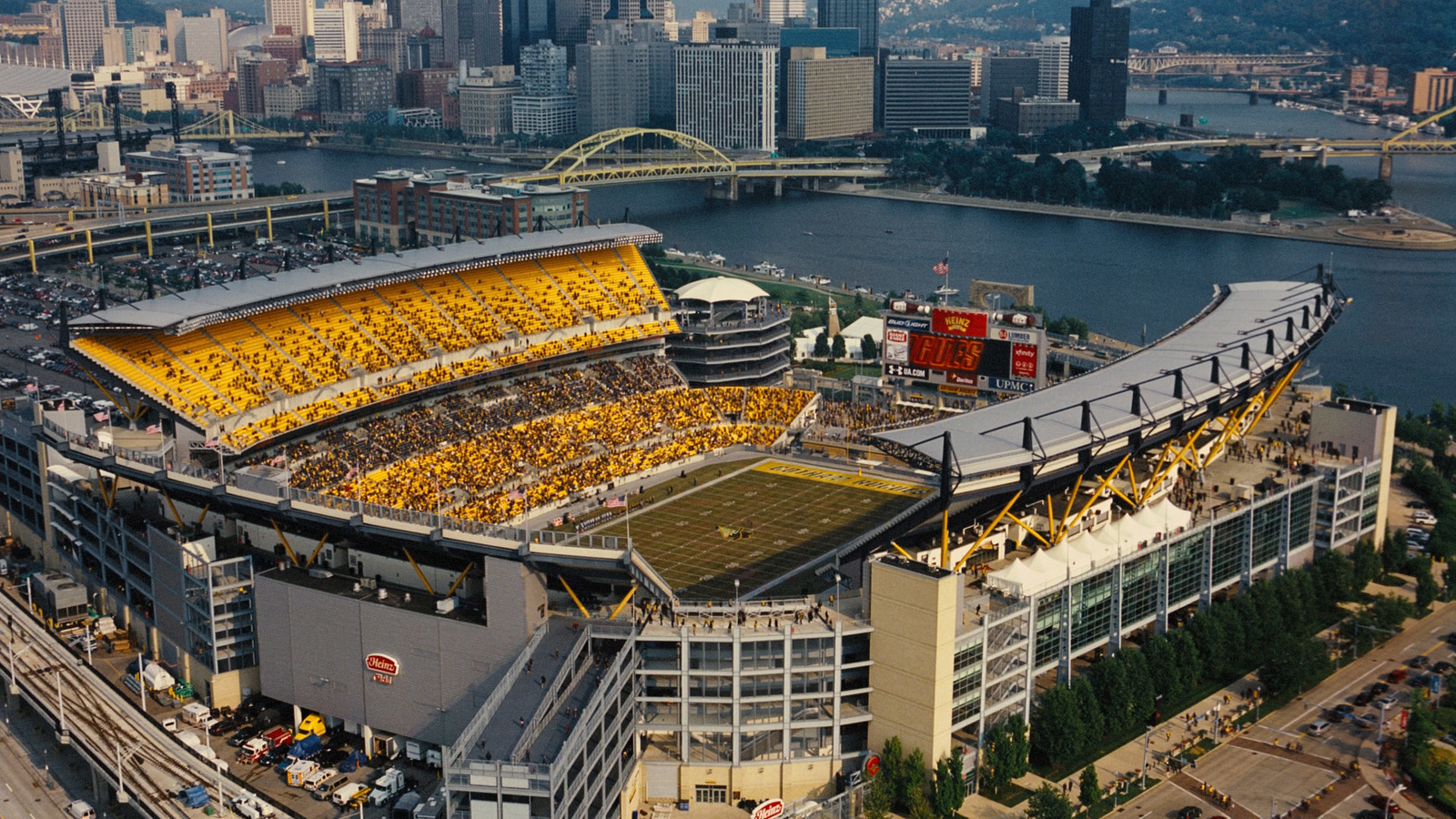 an aerial view of a stadium with a river in the background