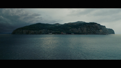 a large body of water with a mountain in the background