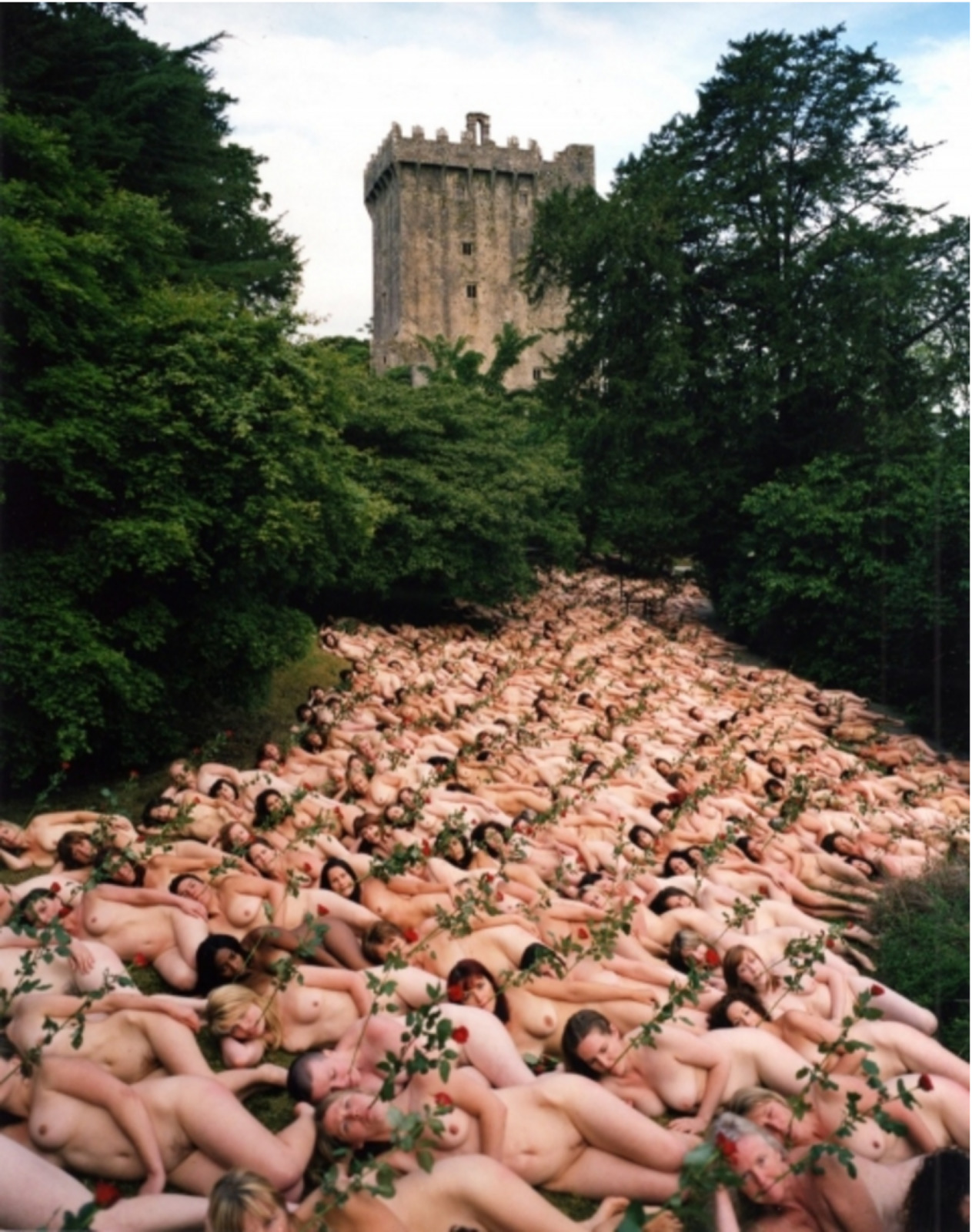 a large group of naked people in front of a castle